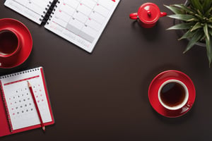Top view look at office desktop surface, dark oak texture material as one single piece, notebook, pencils, red cup of tea, table light, office stuffs, calendar. Professional photo, detailed view, 8K, UHD, contrasted, wallpaper,more detail XL