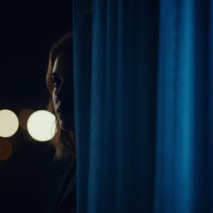 cinematic film still of   A silhouette photo of a pretty woman looking at camera in a dark street at blue night with her face casting window curtain shadow style, shallow depth of field, vignette, highly detailed, high budget, bokeh, cinemascope, moody, epic, gorgeous, film grain, grainy