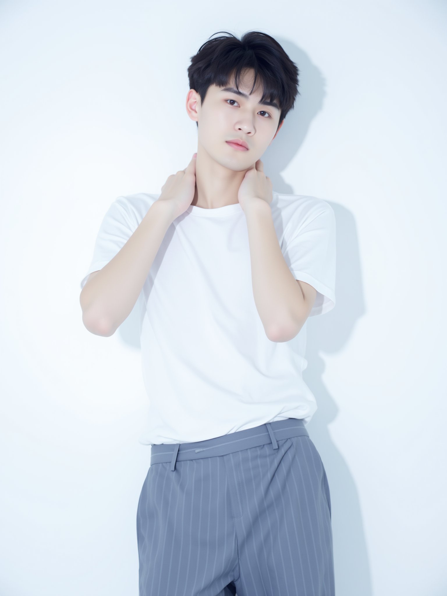 tianhai boy, photograph, young man with short black hair, white t-shirt, blue striped pants, standing against a white background, hands covering his neck, contemplative expression, soft lighting, casual and relaxed atmosphere..<lora:光影人像v2.0:0.8>