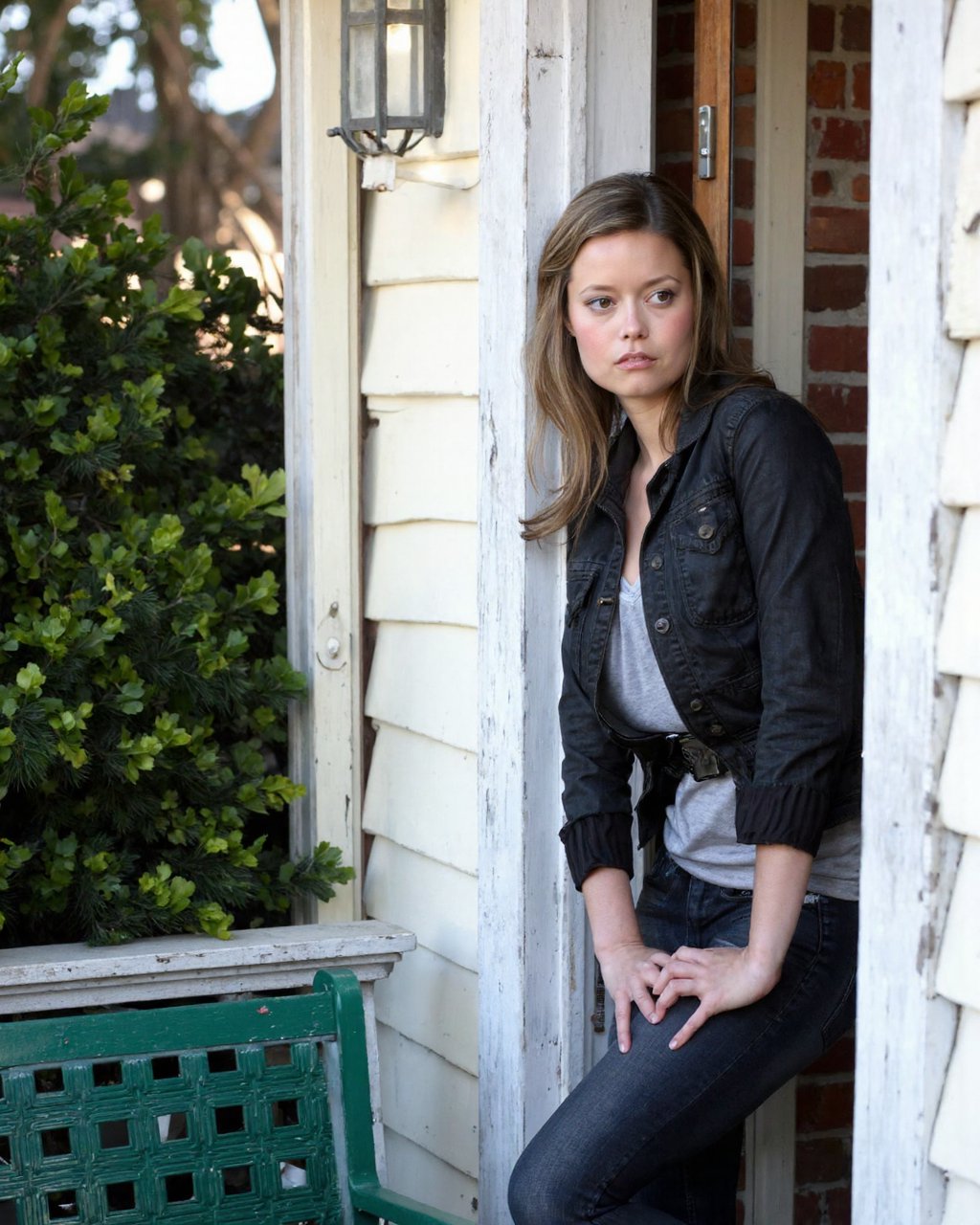 A high-resolution photograph of summer_glau standing in a doorway,  leaning against the frame with a pensive expression. S...