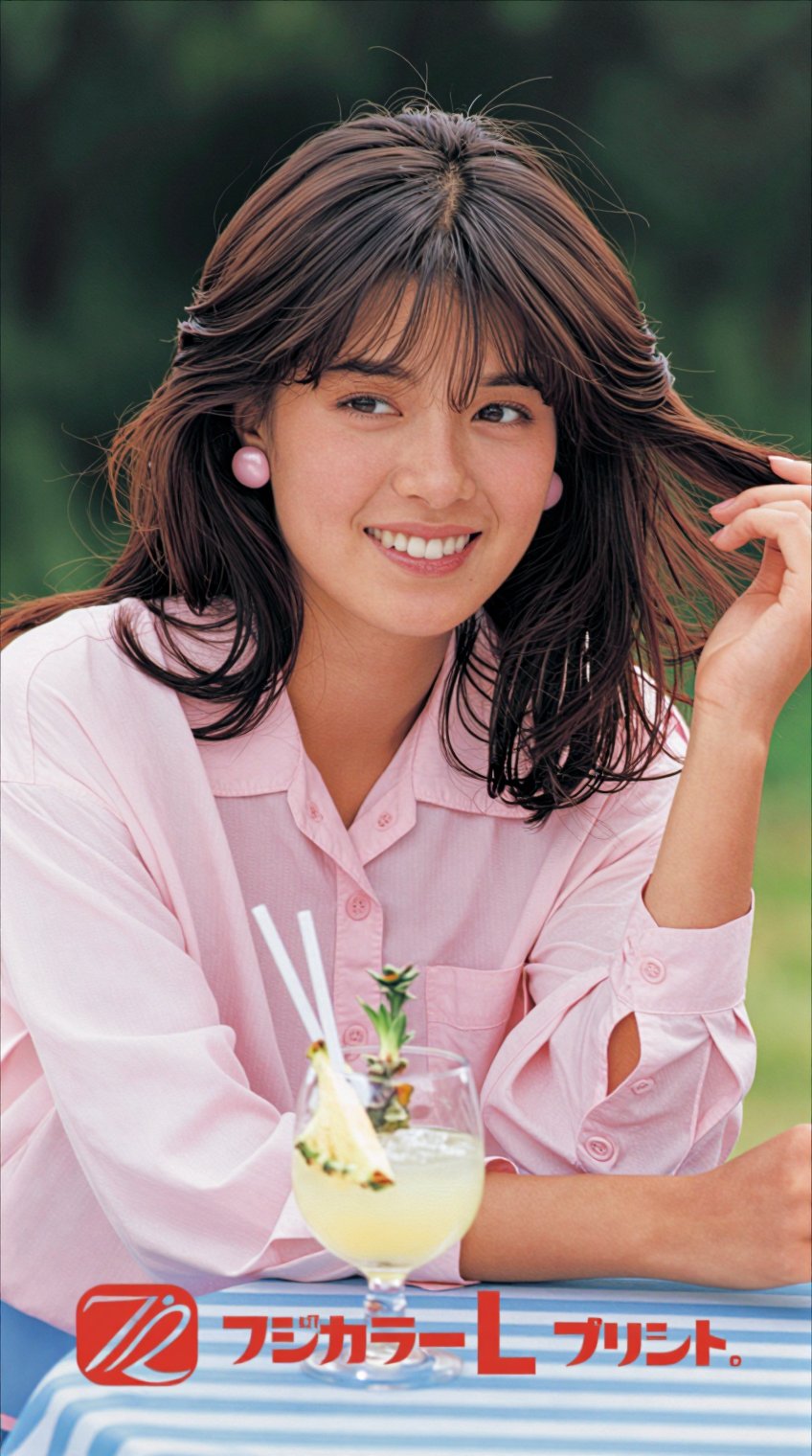 A young woman with shoulder-length brown hair and bangs smiles warmly at the camera,  her right hand gently lifting a stra...