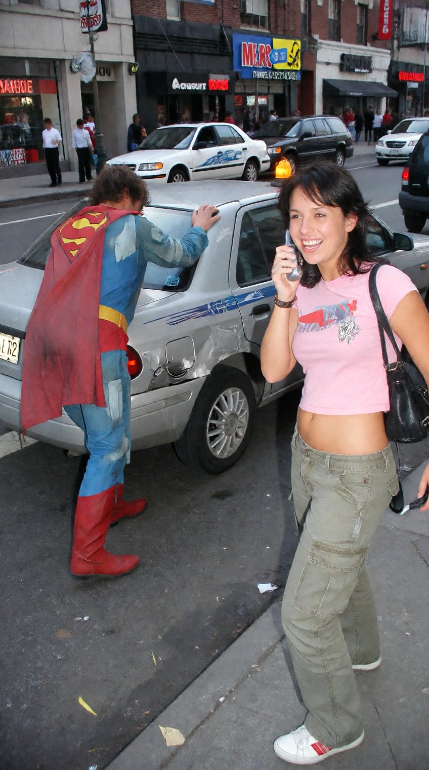 A funny,  candid 2005 snapshot taken on a cheap digital camera. A young woman wearing a pink crop top and cargo pants is s...
