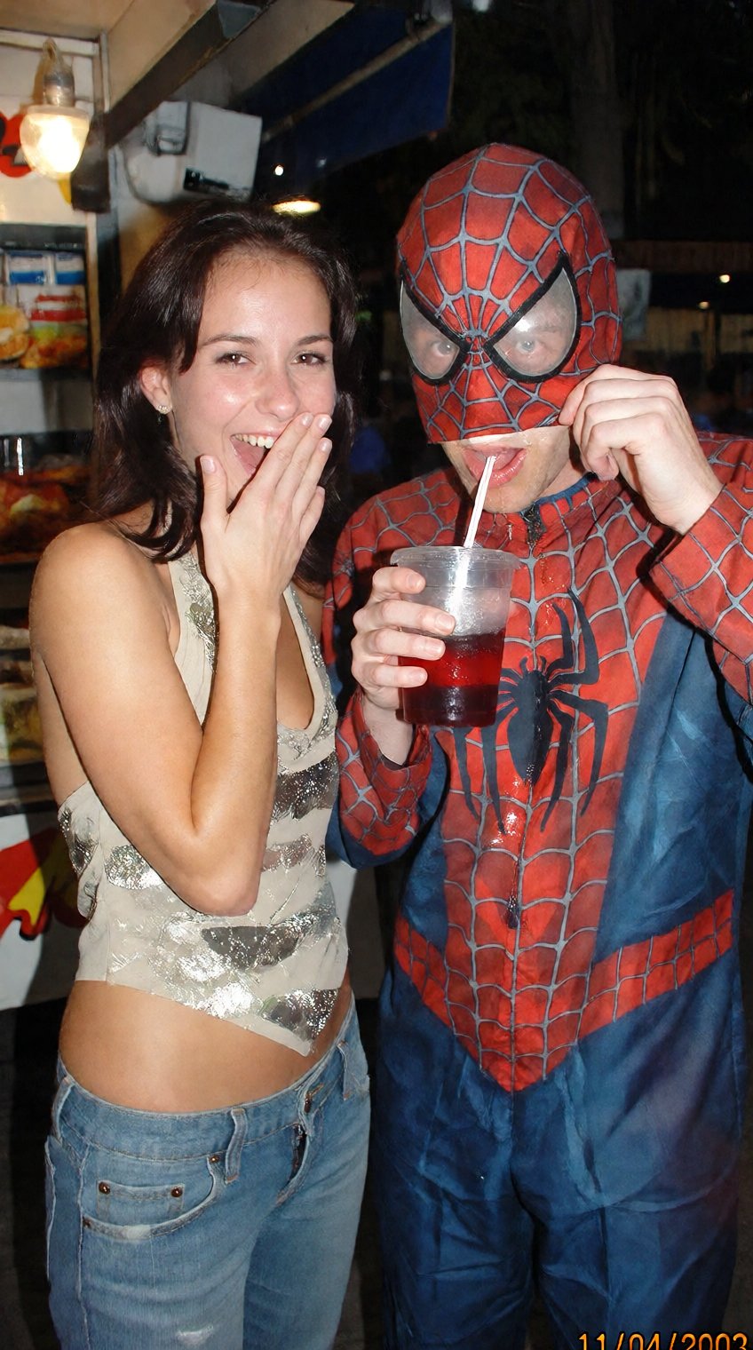 A funny,  candid 2000s digicam photo capturing a hilarious scene at a dimly lit outdoor street food stall at night. A beau...