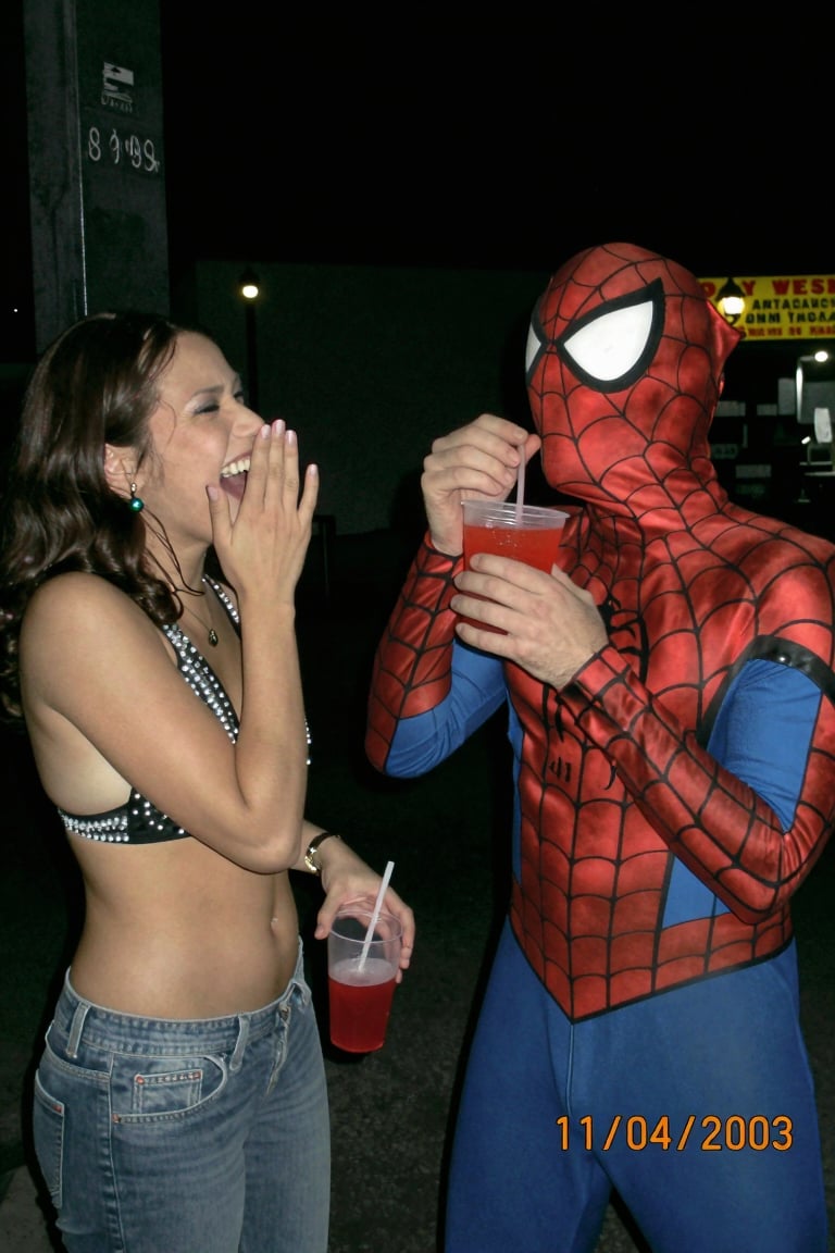 A funny,  candid 2000s digicam photo capturing a hilarious scene at a dimly lit outdoor street food stall at night. A beau...