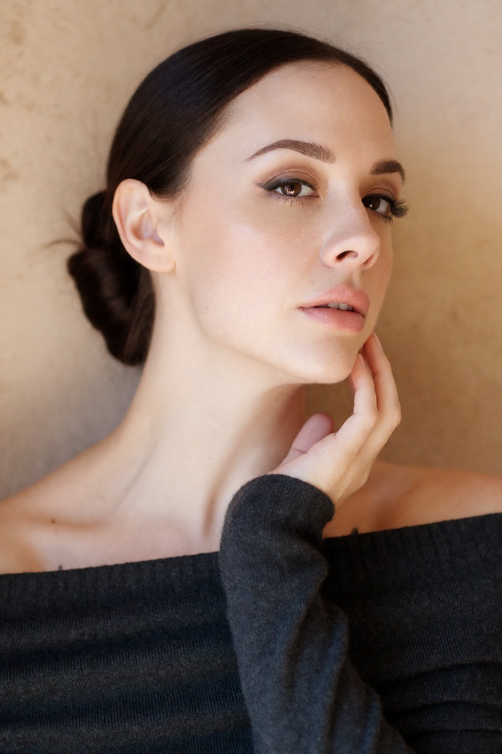A deeply aesthetic,  close-up head and shoulders portrait of woCh40n with dark hair styled in a sleek,  low bun by wesleyo...