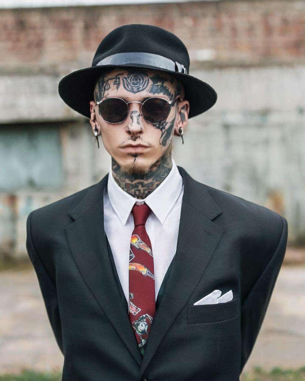 a man in a suit and tie wearing a hat ,  alt_style , alternative culture , alternative style , tattoos:0.2,  <lora:alt_style:1.0>