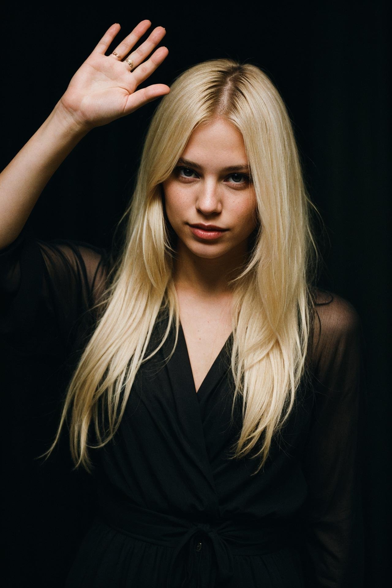 blond female in a dark theme waving goodbye