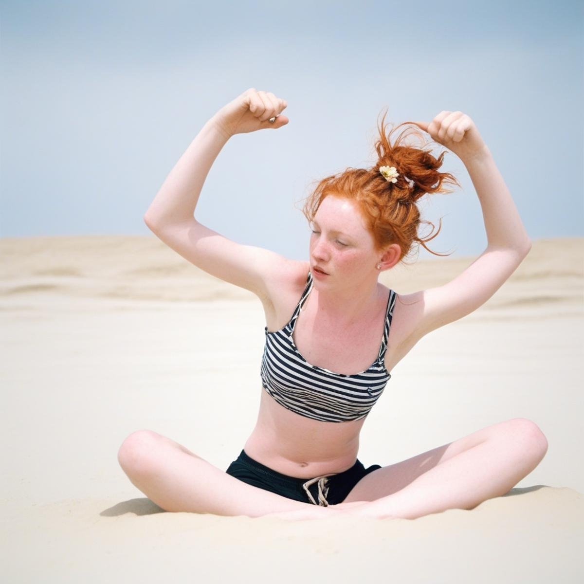 shorts, bra, dolphin shorts, floating hair, lying, arm up, cowboy shot, small breasts, hair flower, messy hair, midriff, hair bun, flat chest, redhead, twin braids, striped, sand