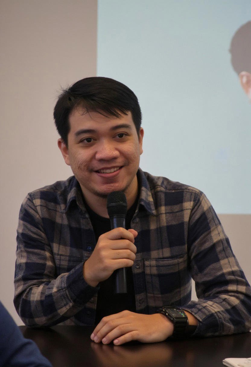 Photorealistic image of a young South east Asian man in his early twenties,  captured mid-shot while speaking into a micro...