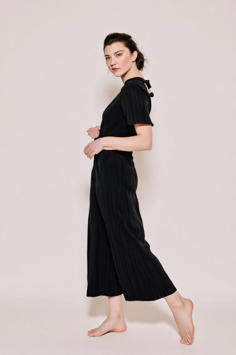 A full-body shot of a breathtakingly glamorous woman in a sophisticated,  minimalist high-fashion outfit,  barefoot. Her f...