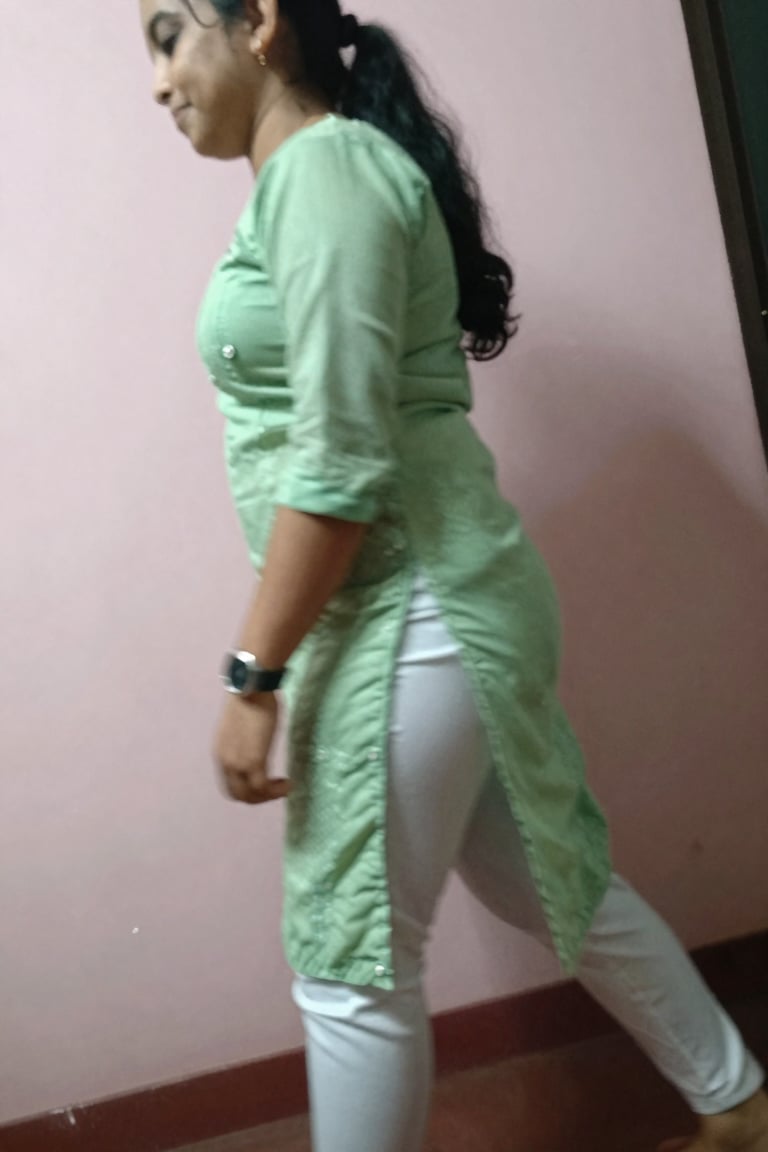 left side close up shot of a low quality blurry mobile photo,  slim ponytail hair girl wearing skurtiDressX,  light green...