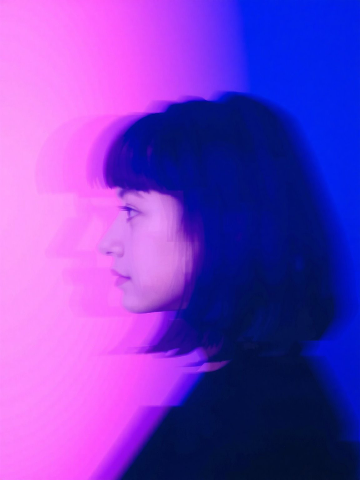 A blurred profile of a person with shoulder-length dark hair,  set against a vibrant,  abstract background. The lighting c...