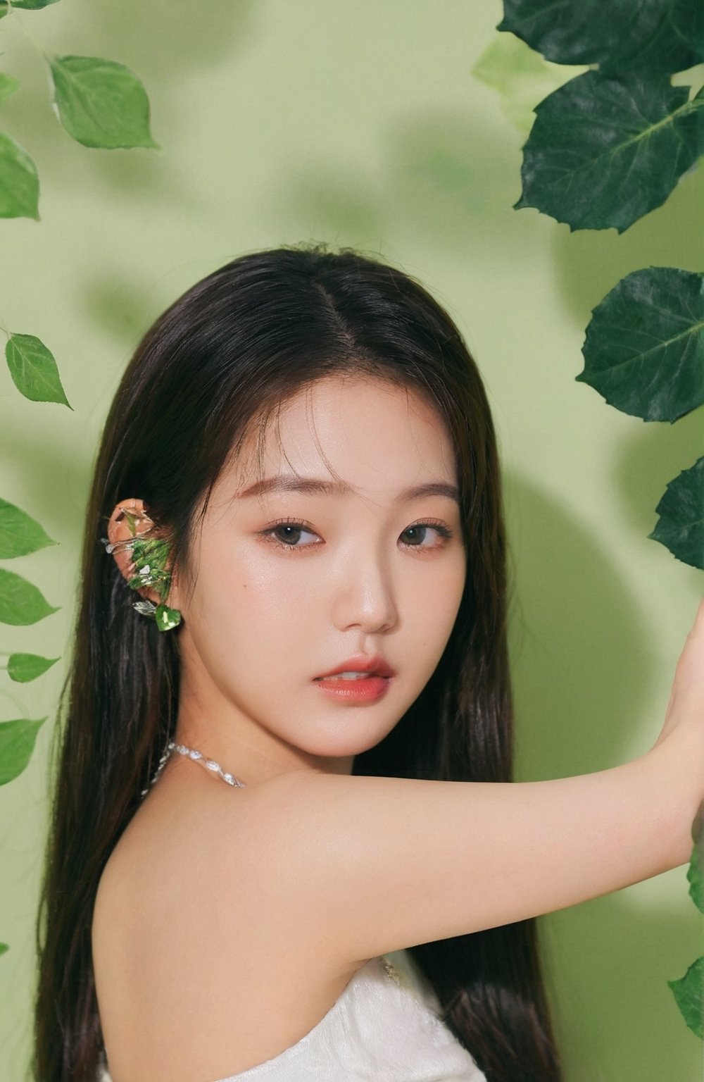 xxmix_girl,a woman with a ring on her finger and a green leaf behind her head and a green background with a green leaf,wonyoung