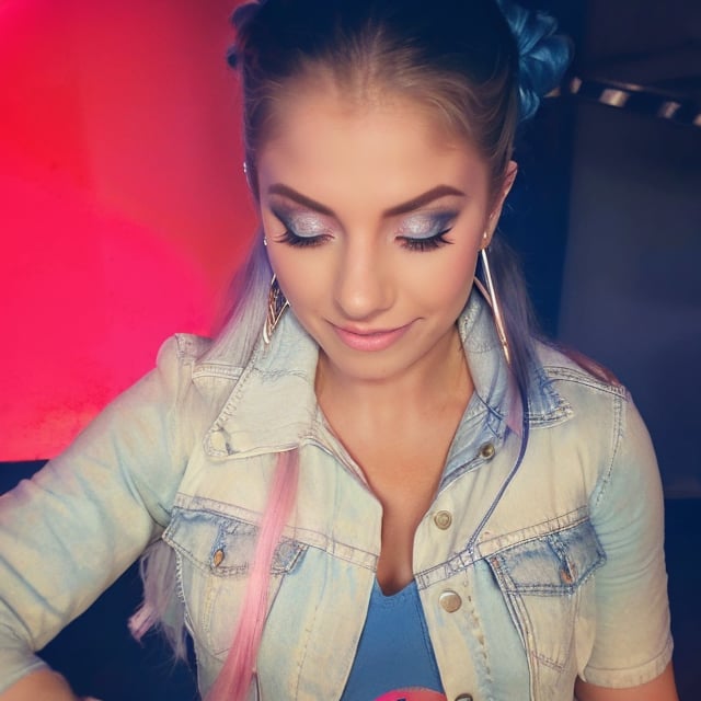 American woman 30 years old resembling Alexa Bliss, she is wearing levis jeans (short, tight, light blue color) and a ex-boyfriend levis denim jacket (light blue color), beautiful long hair, alexa bliss face, alexa bliss hairstyle, harley quinn makeup, posing, daylight, full body image, large hoop earrings, photoshoot