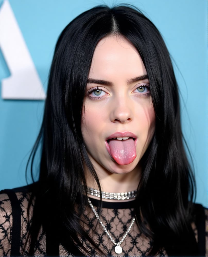 A close-up shot of Billie eilish  with her tongue out. She has black long hair. She is wearing a black lace dress with a silver necklace around her neck. Her hair is long and cascades over her shoulders. Her eyes are blue and her lips are pink. The background is a light blue with a white letter "A" in the upper left corner of the frame.