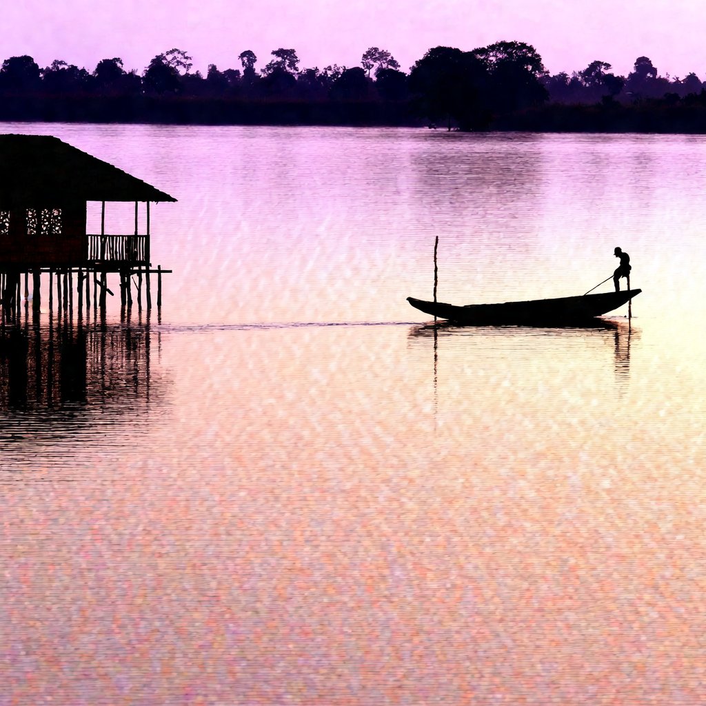 A realistic panoramic view of A traditional Malay wooden house stands gracefully by a calm riverside, surrounded by lush greenery. The house, raised on sturdy stilts, features intricate wooden carvings on its windows and doors, with a small verandah extending towards the river. Near the water's edge, a wooden sampan rests gently, tied to a wooden post. The scene is peaceful, with reflections of the house and trees rippling in the river, giving a sense of timeless rural life.real alamy, perfect anatomy, perfect image 