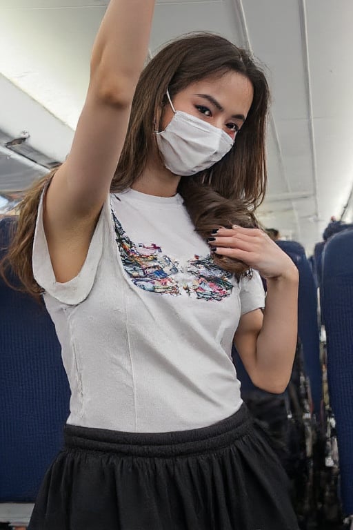 Asian girl with her hair down wearing a white hoodie and black sweatpants wearing a mask taking a selfie on the plane 