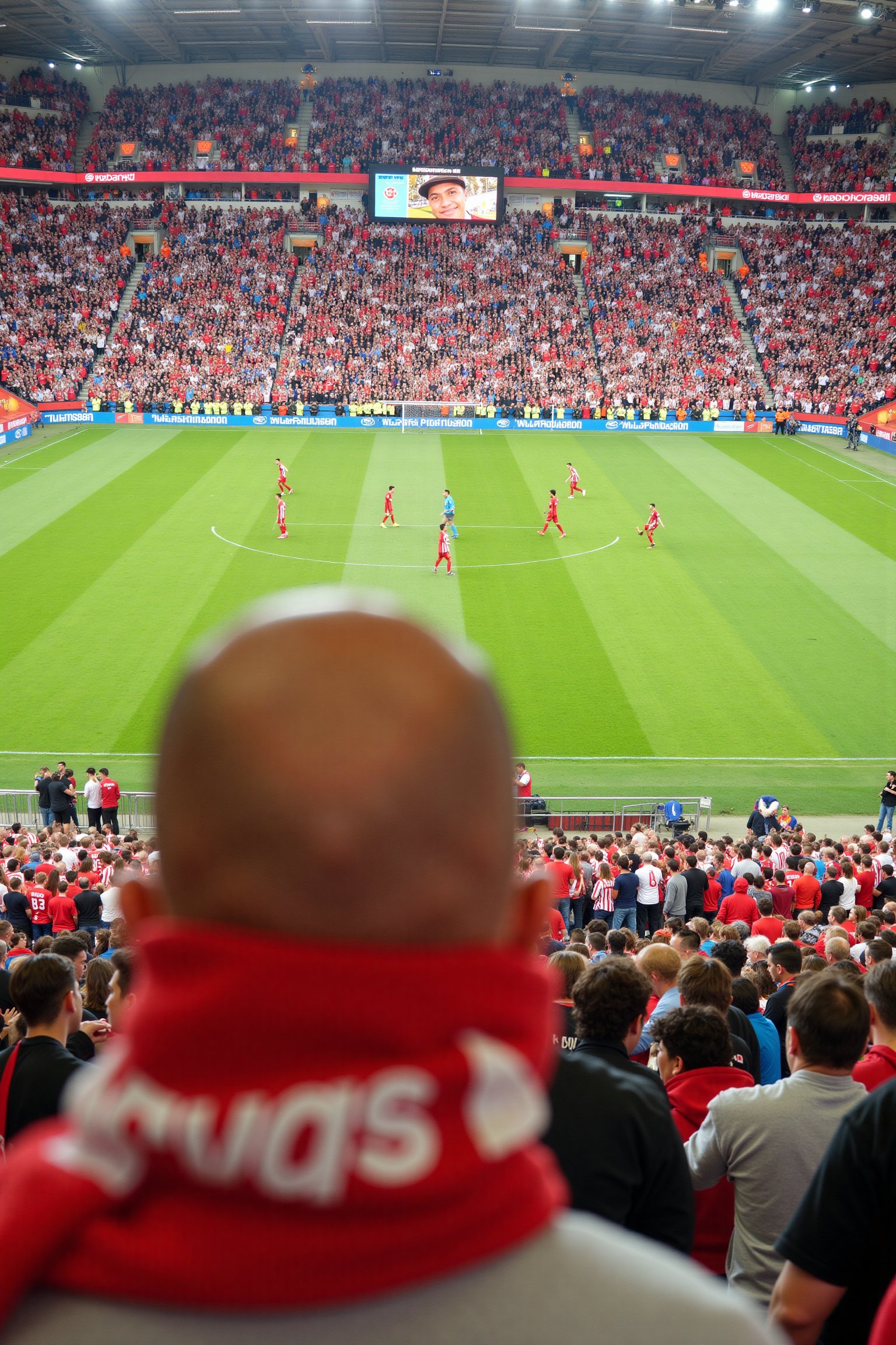 a stadium filled with spectators,  with a large crowd of people wearing red and white. The stadium is brightly lit,  and t...