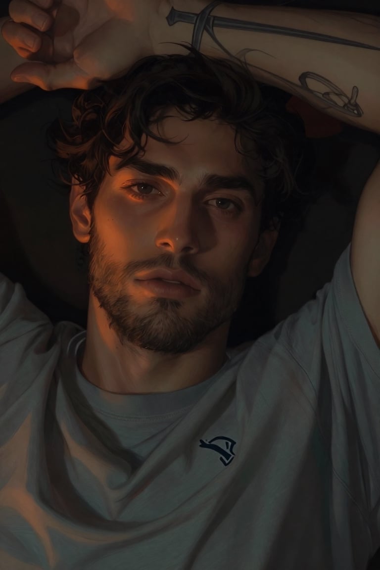 Close-up portrait of a young bearded man lying down,  arm bent above his head revealing forearm tattoos of crossed swords...