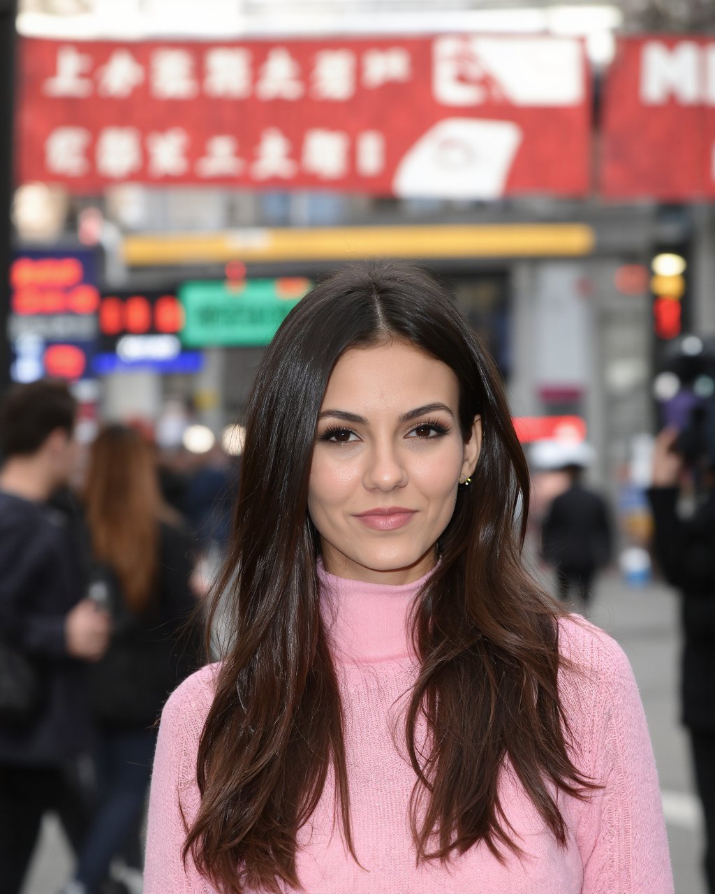 A portrait of victoria_justice in a bustling urban setting. She wears a pink turtleneck sweater and her hair is styled in...