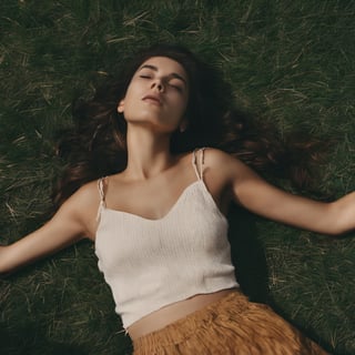 Photo of a woman laying on grass.