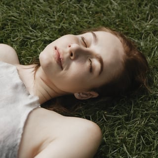 Photo of a woman laying on grass.