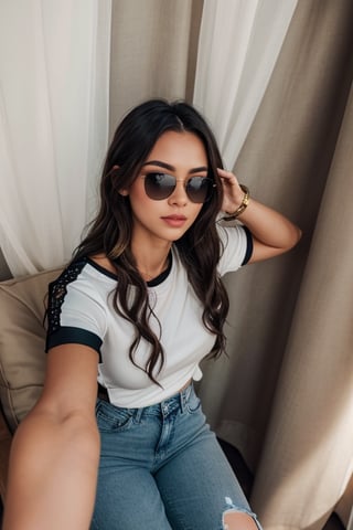 a beautiful female model, a beautiful young woman relaxing in a casual setting. She is wearing sunglasses, a white t-shirt with black sleeves and collar, and blue jeans with a rip at the knee. She has long, wavy hair and is seated comfortably between two beige curtains, creating a cozy atmosphere. The lighting is soft, giving the image a warm and relaxed feel.