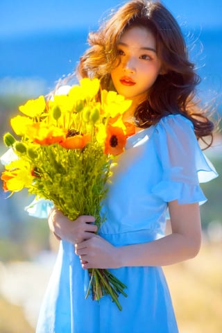 A young woman with wavy brown hair, holding a bouquet of flowers. She is wearing a delicate, translucent white dress and has a soft, pink lipstick on. The flowers she holds are predominantly white with yellow centers, and they appear to be poppies. The background is a soft, muted blue, which contrasts with her skin tone and the white of her dress, making her the focal point of the image.