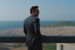 Tony Stark pensativo, observando el horizonte desde el balcón de su mansión. Toma panorámica
