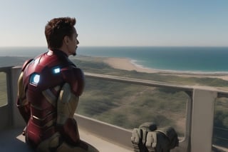 Tony Stark pensativo, observando el horizonte desde el balcón de su mansión. Toma panorámica