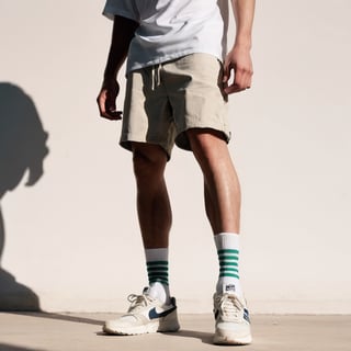 Realistic, Shoes, aesthetic, solo, 1boy, standing, male focus, shoes, shorts, socks, shadow, white footwear, sneakers, close-up, lower body