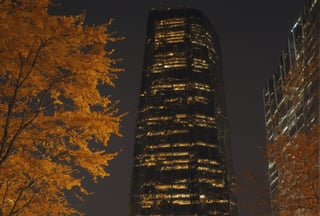 Night, autumn, skyscrapers with orange windows, lanterns highlight the golden foliage of the trees and are reflected in the glass of the skyscrapers