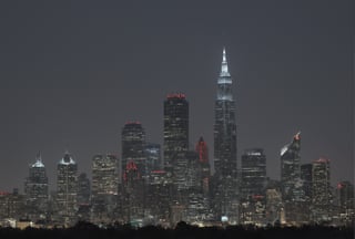 a group of gold square-shaped ornaments on black ground surrounded by gray lines, and gray ornaments with rectangular lines; light bluish gray-light skyscrapers, sometimes with a light greenish tint, with frequent square windows, above two skyscrapers there is a red diode warning aircraft; with a dark gray sky and a clear gray sky illuminated by a bright white-blue moon,